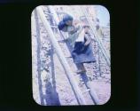 [American Indian with child climbing ladder]