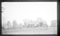 Girl in front of small farmhouse, Oak Lodge Trip