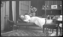 May Gifford reclining on sofa in west room