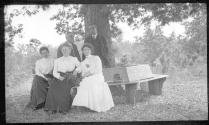 Oak Lodge guests sitting on bench around tree