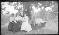 Oak Lodge guests sitting on bench around tree