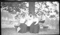 Oak Lodge guests sitting on bench around tree
