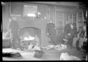George Eastman and guests in living room with dogs, Oak Lodge Trip
