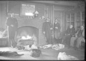 George Eastman and guests in living room with dogs, Oak Lodge Trip