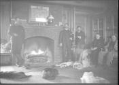George Eastman and guests in living room with dogs, Oak Lodge Trip