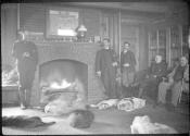 George Eastman and guests in living room with dogs, Oak Lodge Trip