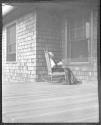 Maria Eastman reading on porch, Oak Lodge Trip