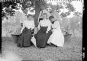 George Eastman and Oak Lodge guests sitting on bench around tree