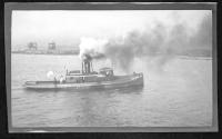 [Steam powered tug on river]