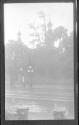 [Street scene, large building beyond trees]
