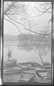 [Rowboats along shore of river]