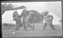 [Men dressed as indians at campsite]