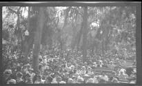 [Large group on benches in park]