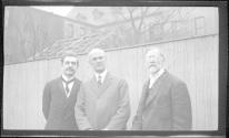 [Three men by fence]