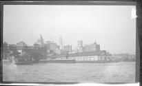 [View of ferry boat slips, city skyline in distance]