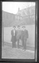 [Three men by fence]