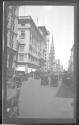 [Street scene with automobiles & horse drawn carriages]