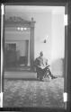 [Portrait of man by large mirror]