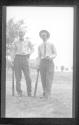 [Two men with baseball bats]