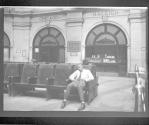 [African American man sleeping in train station (Colored Section)]