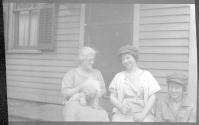 [Three women & cat on porch]