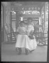 [Woman & child on rocker on porch]