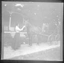 Woman petting horse in front of house