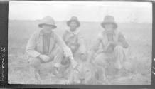 Two hunters and their native guide others posing with dead lion, African Safari