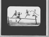 Men jumping a hurdle