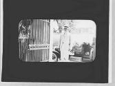 George Eastman beside gate and automobile, Jamaica Trip