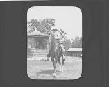George Eastman on horse in yard, Oak Lodge Trip
