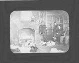 George Eastman and friends and dogs sitting by fire in Oak Lodge, Oak Lodge Trip
