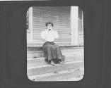 Mary Mulligan sitting on porch, Oak Lodge Trip