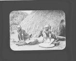 Native women at work in front of huts