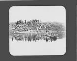 Group of natives on bank of river