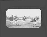 Men playing field hockey