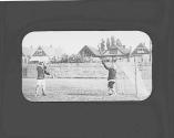 Two people playing lacrosse