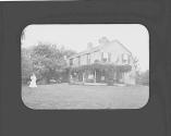 Woman in yard near house, Petersham Motor Trip