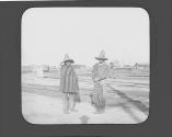 Two mexican boys standing near train tracks