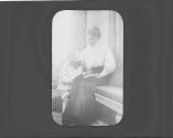Ellen and George Eastman Dryden looking at book in Conservatory