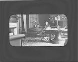 George Eastman sitting in west room by fireplace