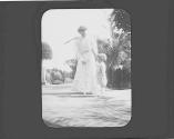 Woman on lawn with Watson Newhall in Eastman's garden