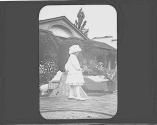 Ellen Maria Dryden pulling doll basket in garden