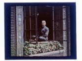 [Man seated on window ledge]