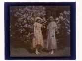 [Two women in front of lilacs]