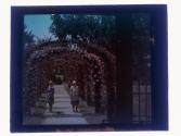 [Two women under flowered arches]
