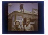 [Two men outside photo shop]
