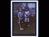 [Two girls in front of flowering bush]