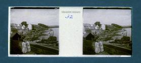 [Woman on path overlooking village and water]
