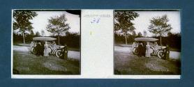 [Woman and two men by car on roadside]